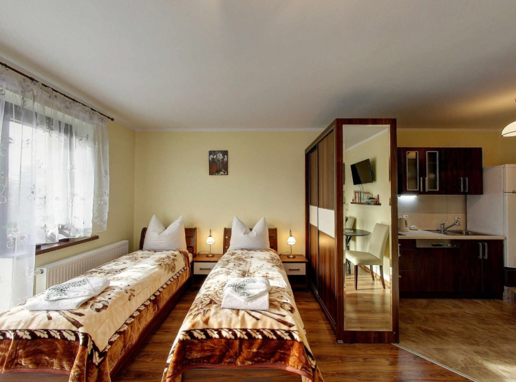 Powiększ obraz: Villa Jura - pokój tarasowy, widok części sypialnej, szafy oraz aneksu kuchennego